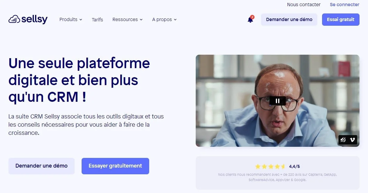 Page web de Sellsy présentant un CRM avec des options d'essai gratuit et de démo. Image d'un homme avec des lunettes sur fond blanc. Note de satisfaction 4,4/5.